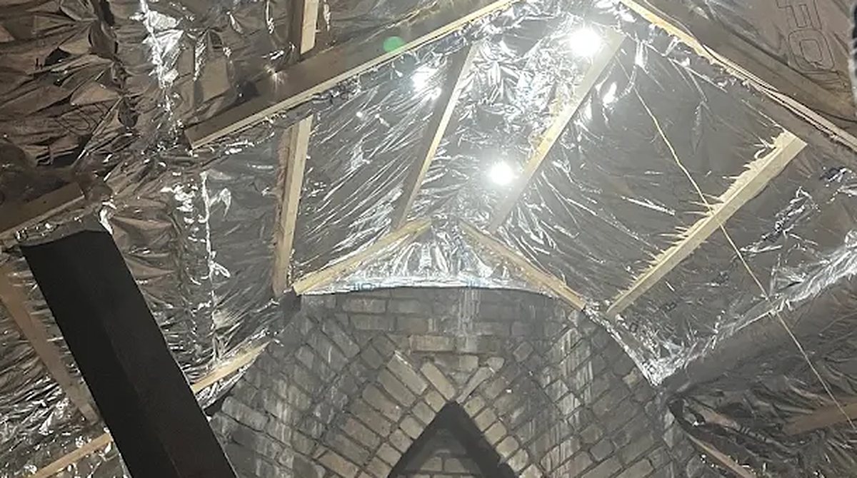 SuperFOIL multifoil fitted and taped across the rafters of a loft with a brick gable wall, installed by our Cardiff team