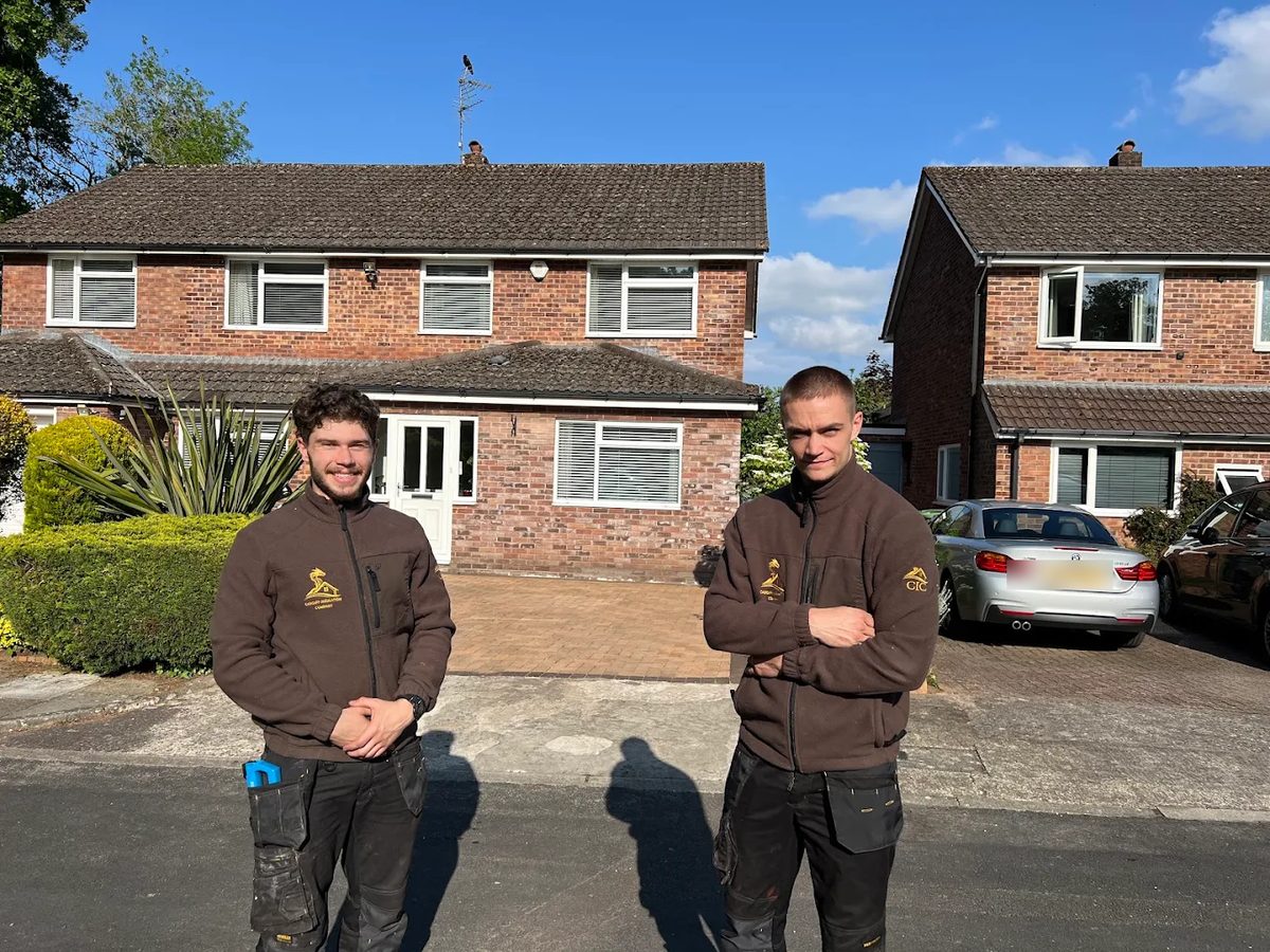 Two Cardiff Insulation Company installers in branded fleeces outside a house in Cardiff