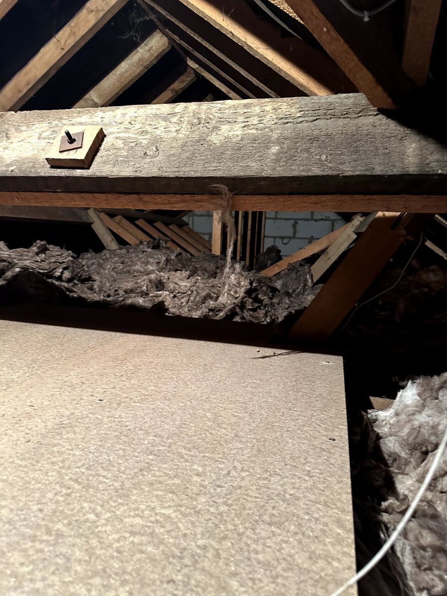 Chipboard loft panels laid next to the hatch in an older loft