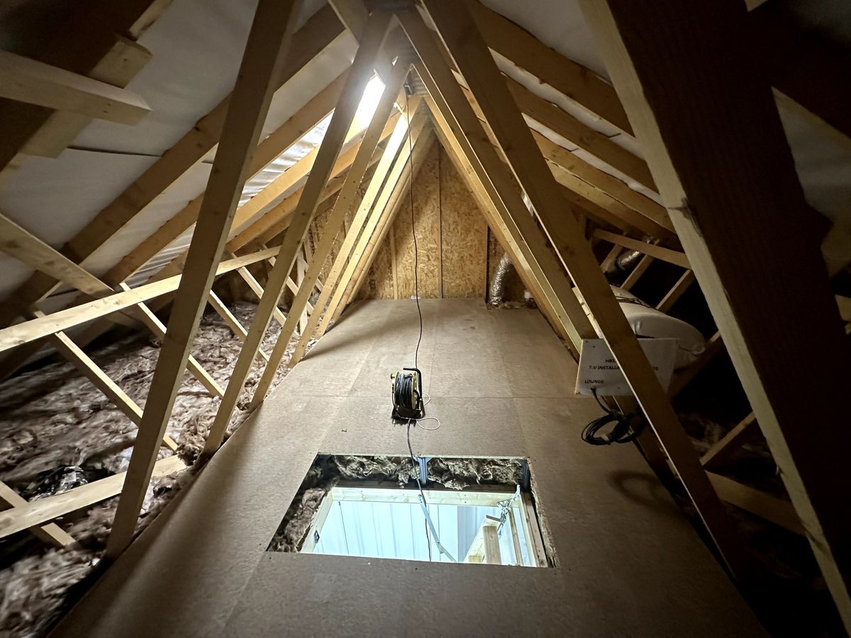 Chipboard loft boarding laid down the centre of a trussed loft around the loft hatch